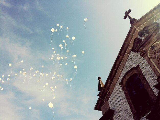 Zdjęcie niski kąt widoku balonów i kościoła na tle nieba