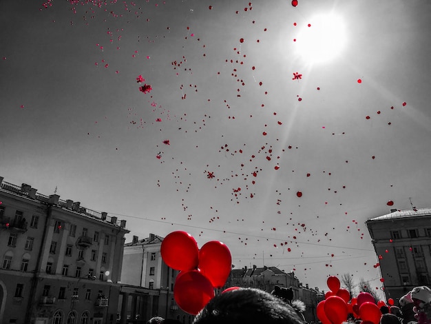 Zdjęcie niski kąt widoku czerwonych balonów na tle nieba w mieście