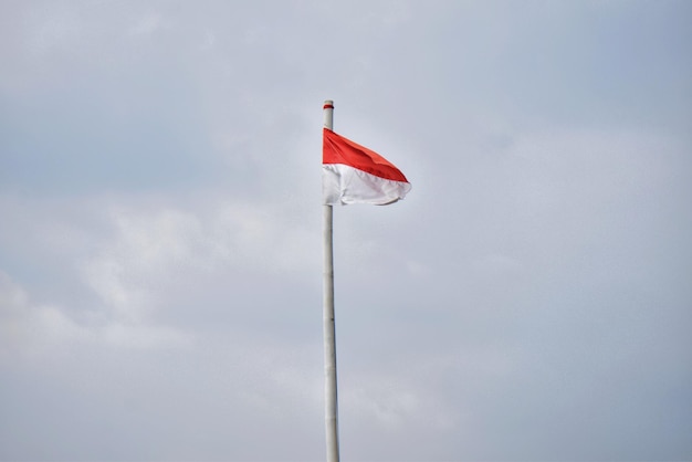 Niski kąt widoku flagi indonezyjskiej na tle nieba