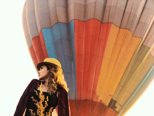 Zdjęcie niski kąt widoku kobiety stojącej przed balonem na gorące powietrze