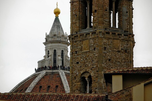 Zdjęcie niski kąt widoku ludzi na kopuły katedry we florencji na czystym niebie
