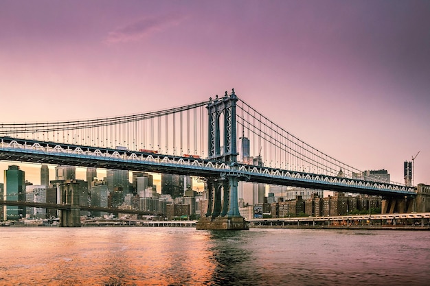 Niski kąt widoku mostu Manhattana na tle horyzontu w zmierzchu
