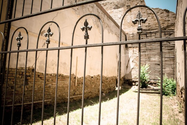 Niski kąt widoku opuszczonego budynku widzianego przez metalową bramę w Jerome