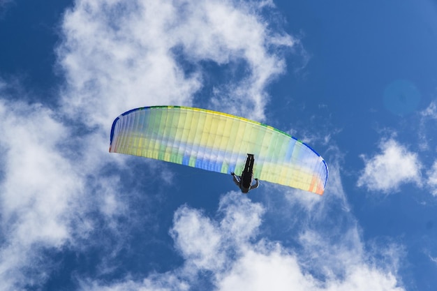 Zdjęcie niski kąt widoku osoby latającej na paragliderze na tle nieba