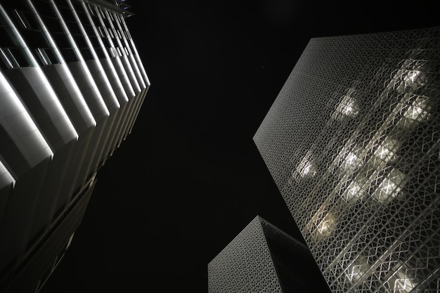 Zdjęcie niski kąt widoku oświetlonego nowoczesnego budynku w nocy