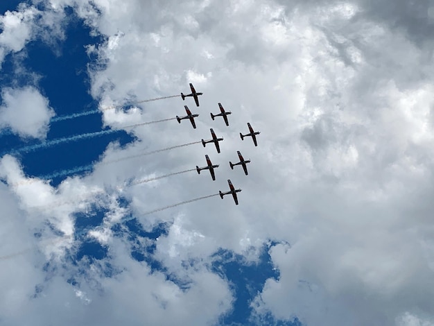 Zdjęcie niski kąt widoku pokazu lotniczego na chmurnym niebie