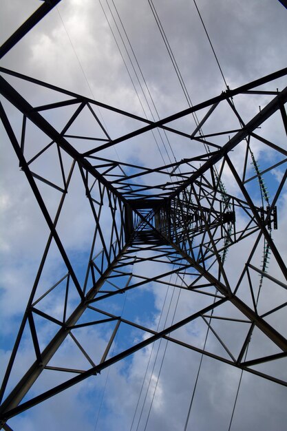 Zdjęcie niski kąt widoku pylonu elektrycznego na chmurnym niebie