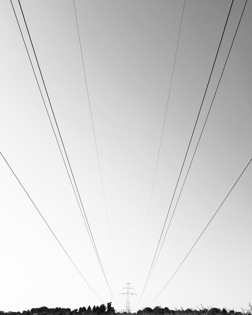 Zdjęcie niski kąt widoku pylonu elektrycznego na jasnym niebie