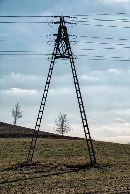 Zdjęcie niski kąt widoku pylonu elektrycznego na polu na tle nieba