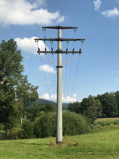 Zdjęcie niski kąt widoku pylonu elektrycznego na polu na tle nieba