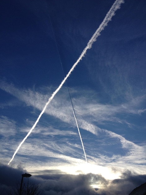 Zdjęcie niski kąt widoku ścieżki pary na tle niebieskiego nieba