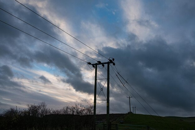 Zdjęcie niski kąt widoku sylwetki pylonu elektrycznego na tle nieba