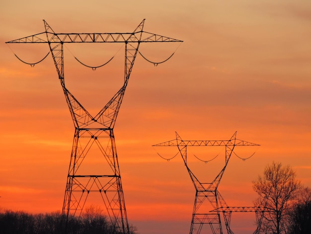 Zdjęcie niski kąt widoku sylwetki słupa elektrycznego na tle nieba podczas zachodu słońca