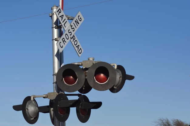 Niski kąt widoku torów kolejowych na tle jasnego niebieskiego nieba