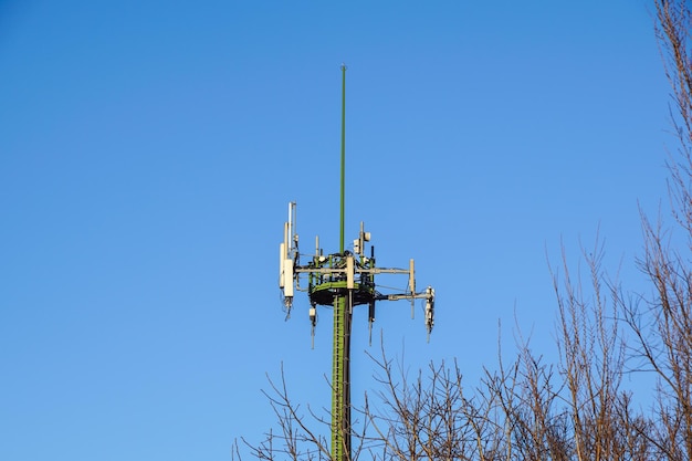 Zdjęcie niski kąt widoku wieży komunikacyjnej na tle jasnego niebieskiego nieba