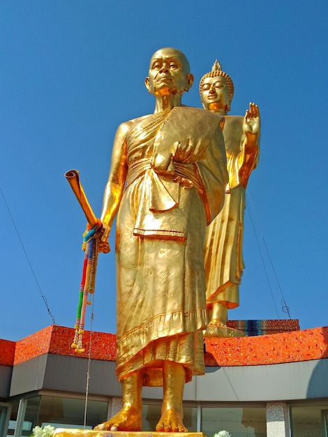 Zdjęcie niski kąt widoku złotych posągów na tle świątyni na tle czystego niebieskiego nieba
