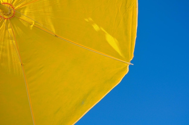 Zdjęcie niski kąt widoku żółtego parasola plażowego na jasnym niebie