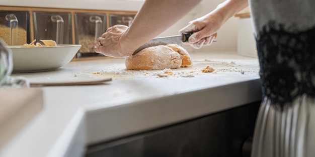 Niski kąt widzenia pod ramionami kobiety robiącej domowe ciasto makaronowe