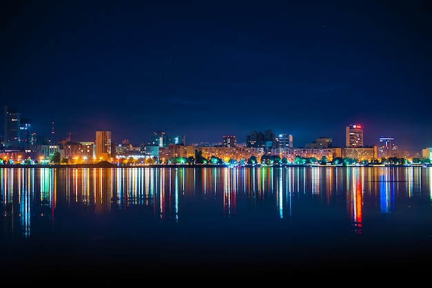 Nocna Panorama Miasta Z Wieloma Kolorowymi światłami Odbijającymi Się W Wodzie