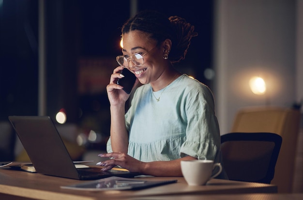 Nocna rozmowa telefoniczna w biurze laptop i szczęśliwa kobieta mówiąca komunikacja i czytanie rozwój projektu KPI lub raport Dyskusja na temat handlu elektronicznego przez telefon komórkowy i uśmiech profesjonalnej osoby przy zamówieniu online