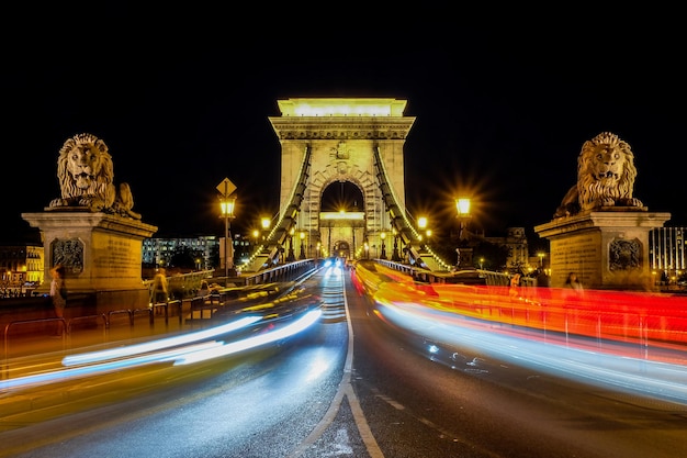 Nocna Scena Oświetlonego Mostu łańcuchowego, Który Obejmuje Dunaj Budapeszt Węgry Czerwony I Biały C