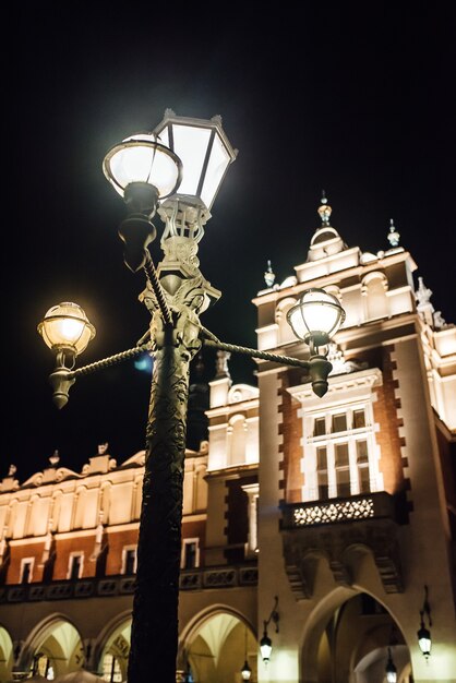 Nocna stara dzielnica handlowa Krakowa w światłach ulicznych latarni. Stara Europa.