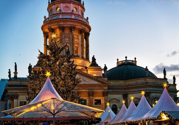 Nocny Jarmark Bożonarodzeniowy na Gendarmenmarkt w zimie Berlin, Niemcy. Dekoracje na jarmark adwentowy i stragany z artykułami rzemieślniczymi na bazarze.