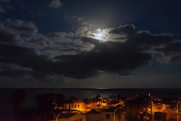 Nocny krajobraz Światło księżyca nad morzem i nocne życie miasta