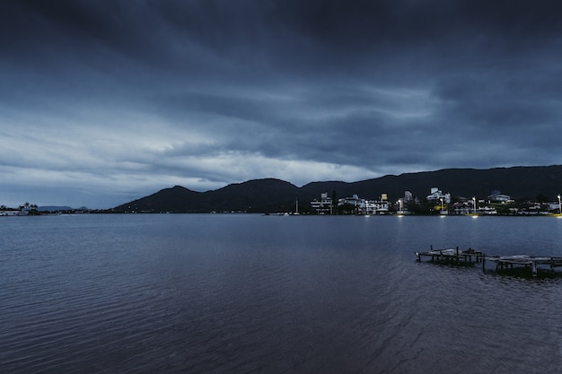 Nocny ocean i ciemne góry rybackie miasteczko nocą wysokiej jakości zdjęcia