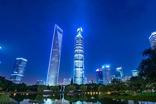 Nocny widok miejskiej zieleni i nowoczesnej architektury w dzielnicy finansowej Lujiazui w Szanghaju