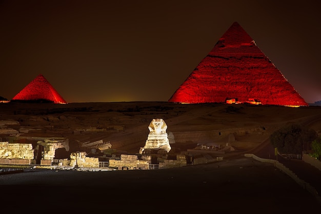 Nocny widok na oświecone piramidy w Gizie, Egipt.