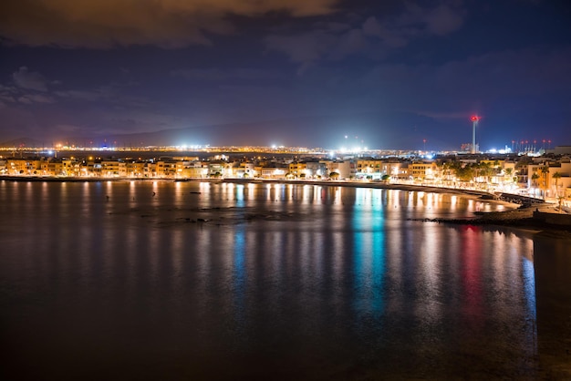 Nocny widok na oświetlone nadmorskie miasteczko Arinago. Gran Canaria, Hiszpania