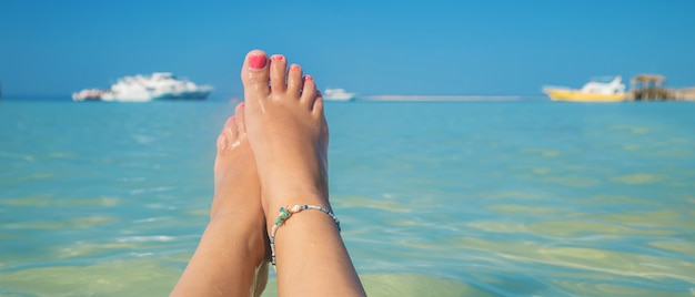 Nogi dziewczyny nad brzegiem morza.