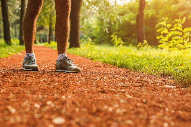 Nogi i buty do biegania zbliżenie człowieka jogging na świeżym powietrzu na drodze