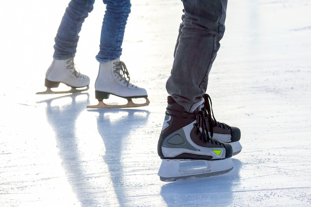 Nogi mężczyzny na łyżwach na lodowisku. Sport i rozrywka. Wypoczynek i ferie zimowe