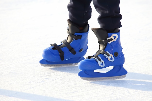Nogi w niebieskiej jeździe na łyżwach na lodowisku