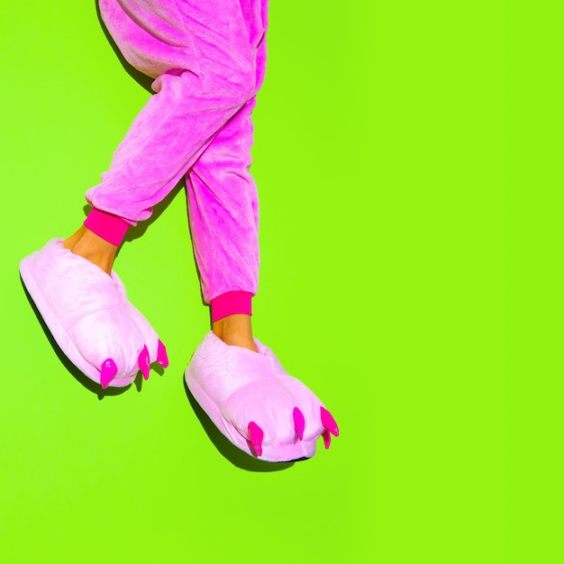 Nogi w różowym kigurumi Piżama i kapcie Zostań w domu Koncepcja przyjęcia w piżamie Minimalne modne cukierki