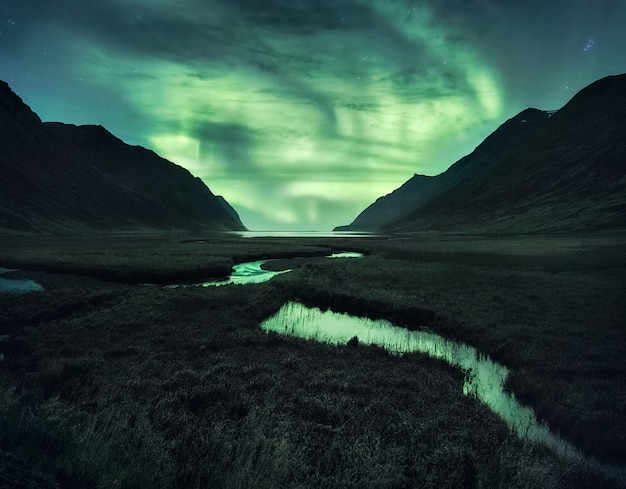 Northen Lights pod górami. Piękny naturalny krajobraz na Islandii.