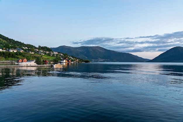 Norweskie fiordy wiejski krajobraz górski widok na morze, wieś Rosendal domy na zielonym wzgórzu.