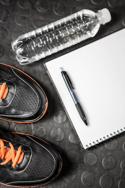 Zdjęcie notatnik, buty i butelka w siłowni crossfit