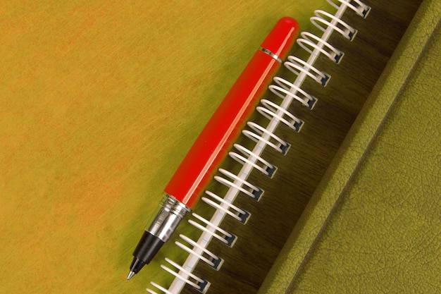 Notatnik I Czerwony Długopis Leżący Na Drewnianym Biurku. Przedmioty Do Biura I Edukacji