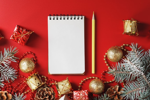 Notatnik i ołówek do pisania życzeń i prezentów na Nowy Rok i Boże Narodzenie wokół choinki