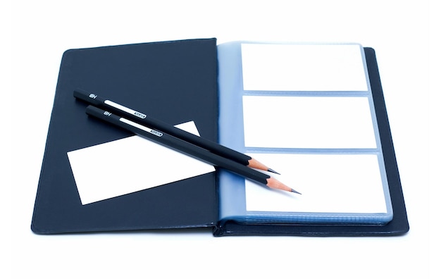 Notatnik i ołówki (ścieżka przycinająca) odizolowywający na białym tle
