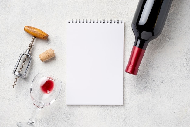 Notatnik obok butelki wina i szklanek
