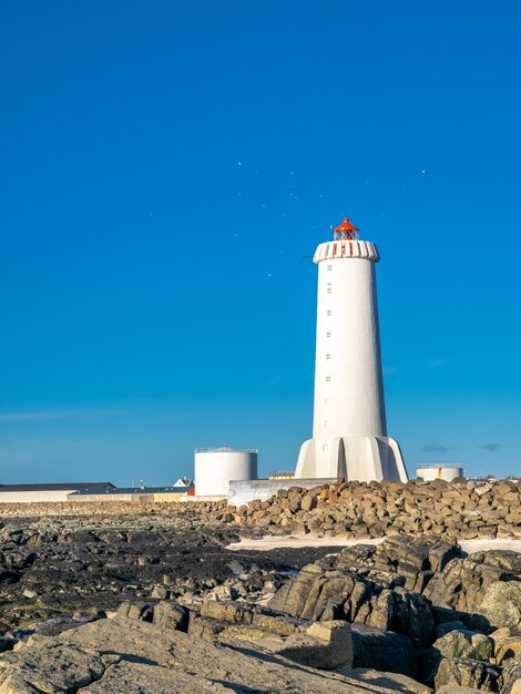 Nowa aktywna wieża latarni morskiej Akranes na końcu półwyspu w mieście pod błękitnym niebem Islandia