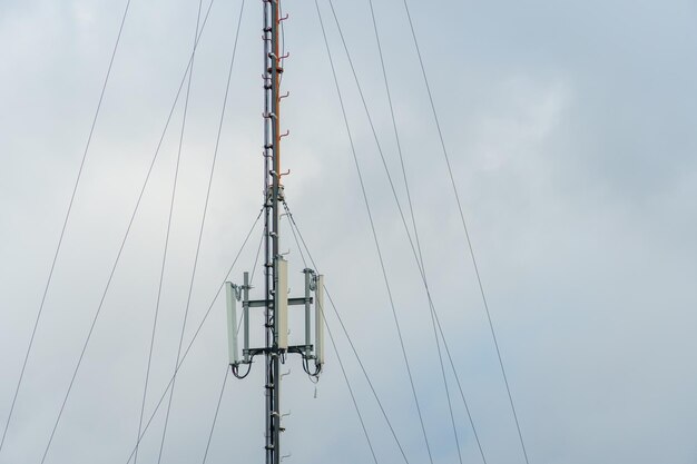 Nowe anteny GSM na wieży na tle błękitnego nieba do transmisji sygnału 5g są niebezpieczne Zanieczyszczenie promieniowaniem środowiska przez wieże komórkowe Nowe technologie w dziedzinie komunikacji