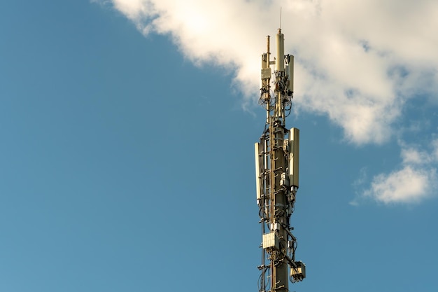 Nowe anteny GSM na wysokiej wieży na tle błękitnego nieba do transmisji sygnału 5g są niebezpieczne dla zdrowia Zanieczyszczenie środowiska promieniowaniem przez wieże komórkowe Zagrożenie wyginięciem