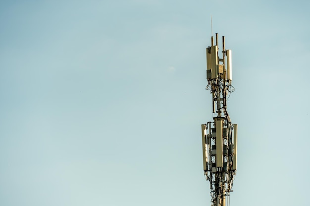 Nowe anteny GSM na wysokiej wieży na tle błękitnego nieba do transmisji sygnału 5g są niebezpieczne dla zdrowia Zanieczyszczenie środowiska promieniowaniem przez wieże komórkowe Zagrożenie wyginięciem