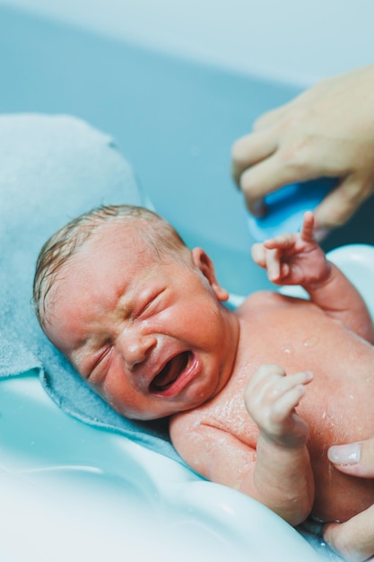 Nowo narodzone dziecko leży w wannie pierwsza kąpiel nowo narodzonego dziecka kąpiel nowo narodzonego dziecka