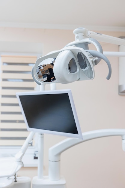 Zdjęcie nowoczesna klinika dentystyczna fotel dentystyczny i inne akcesoria wykorzystywane przez stomatologów w świetle medycznym